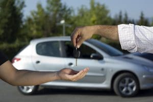 man handing over car keys